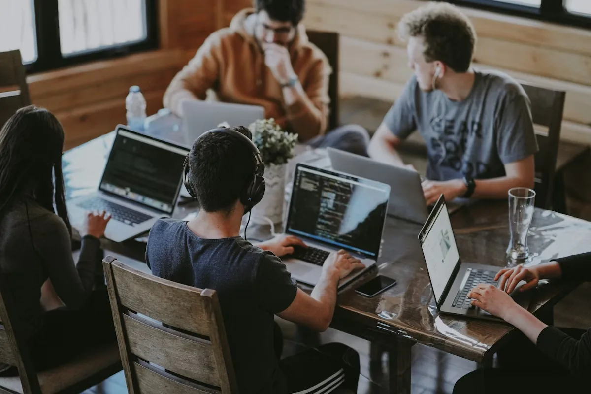 A team working together over laptops around one table